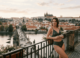 Prague escort in black lace lingerie with coffee overlooking Prague Castle